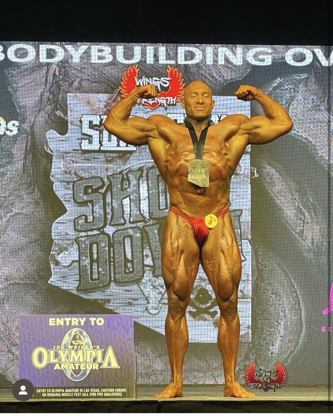 A Cardone Nutrition client competing on stage at a bodybuilding show.